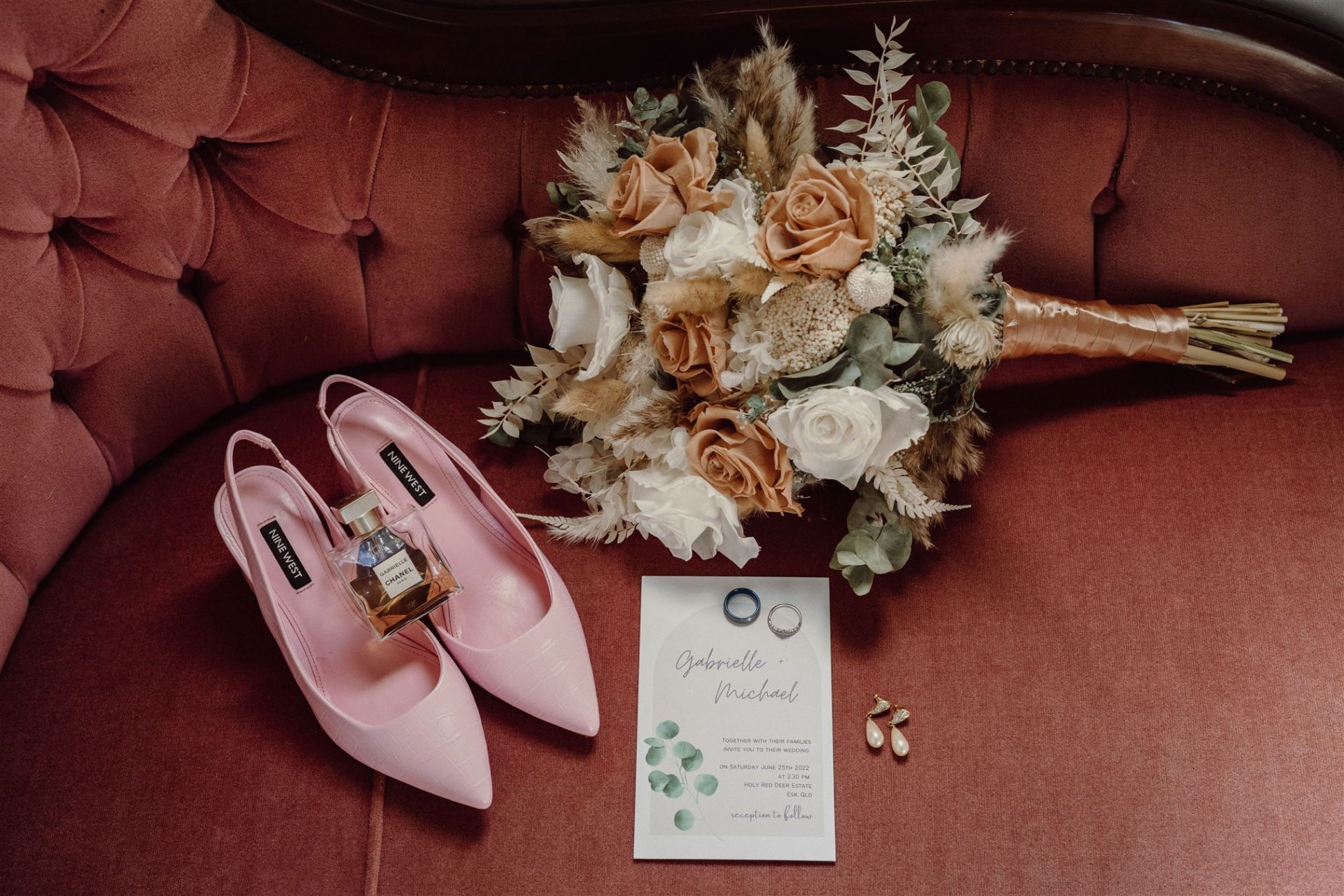 Bridal flowers, shoes and bouquet on red chesterfield couch